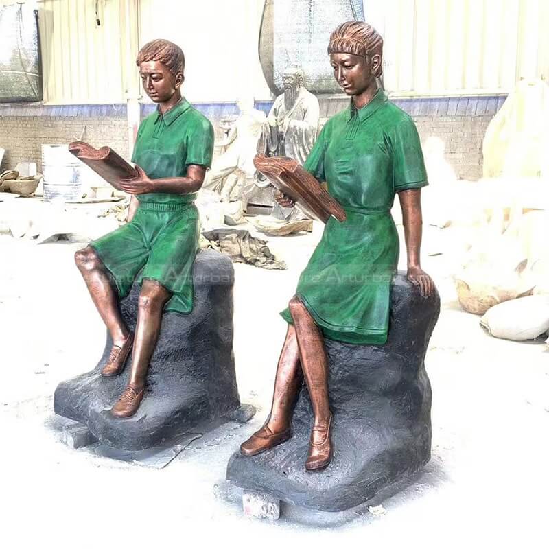 boy and girl reading garden statue