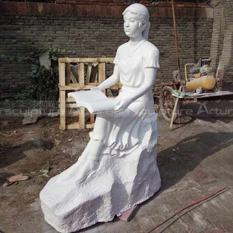 girl reading outdoor statue