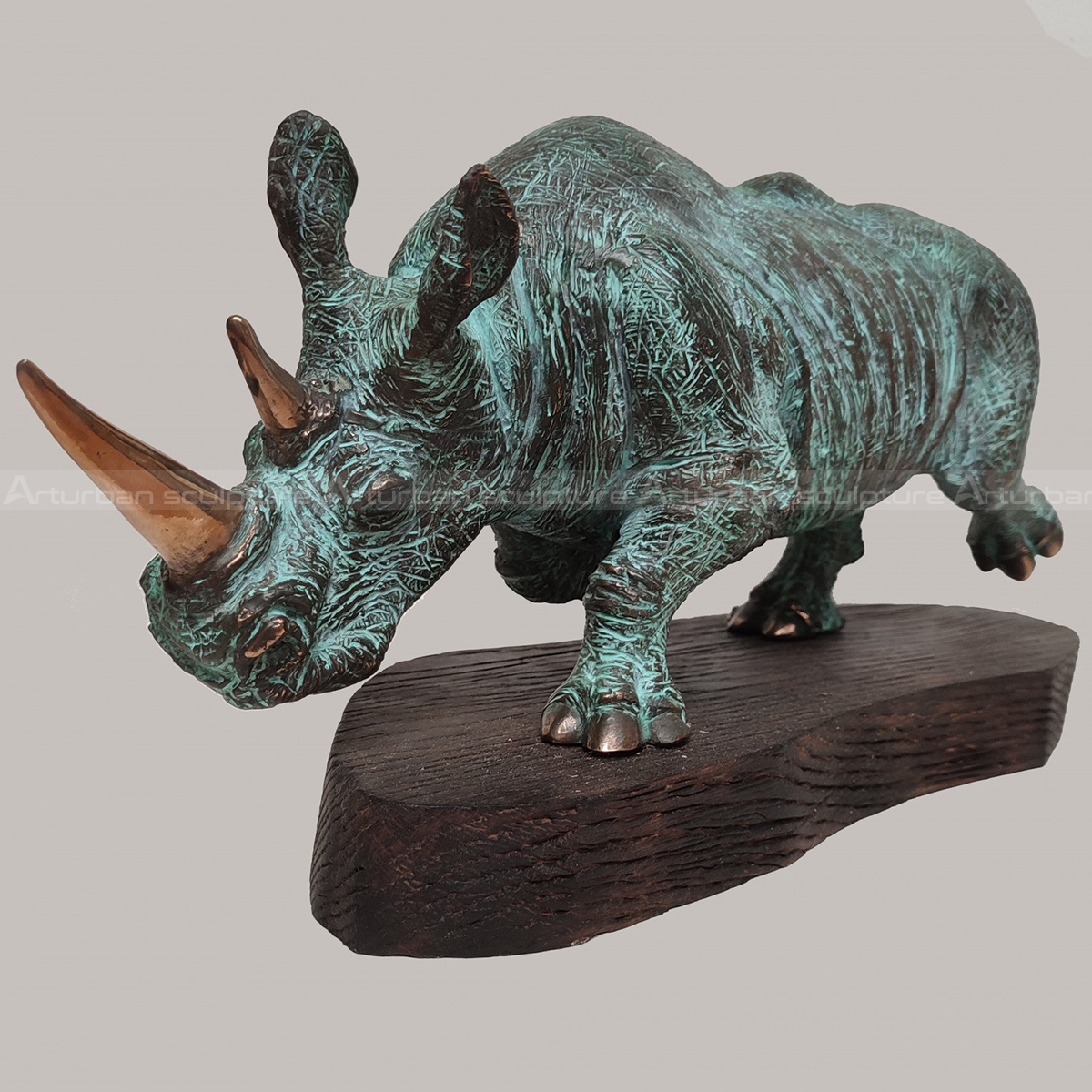 Bronze Rhino Sculpture featuring a green patina finish