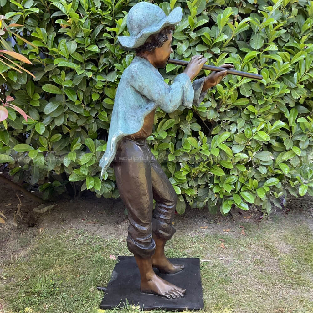 boy playing flute garden sculpture