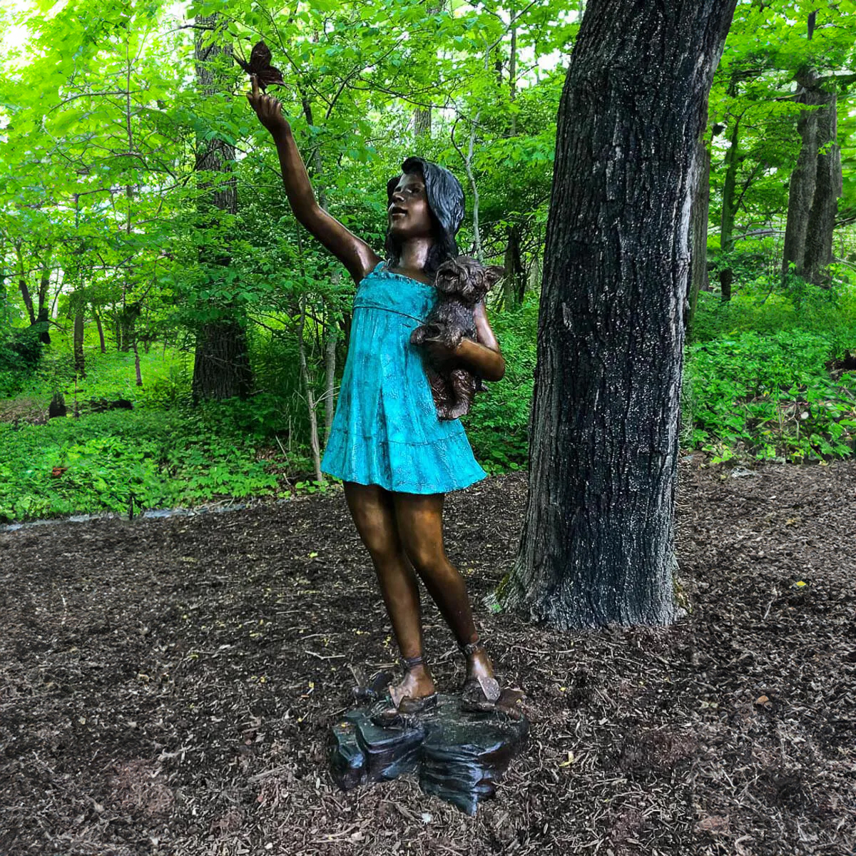 Girl Holding Dog with Butterfly Statue