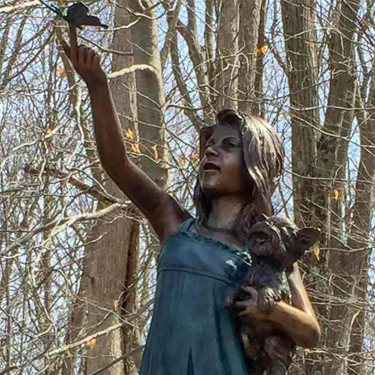 Girl Holding Dog with Butterfly Statue