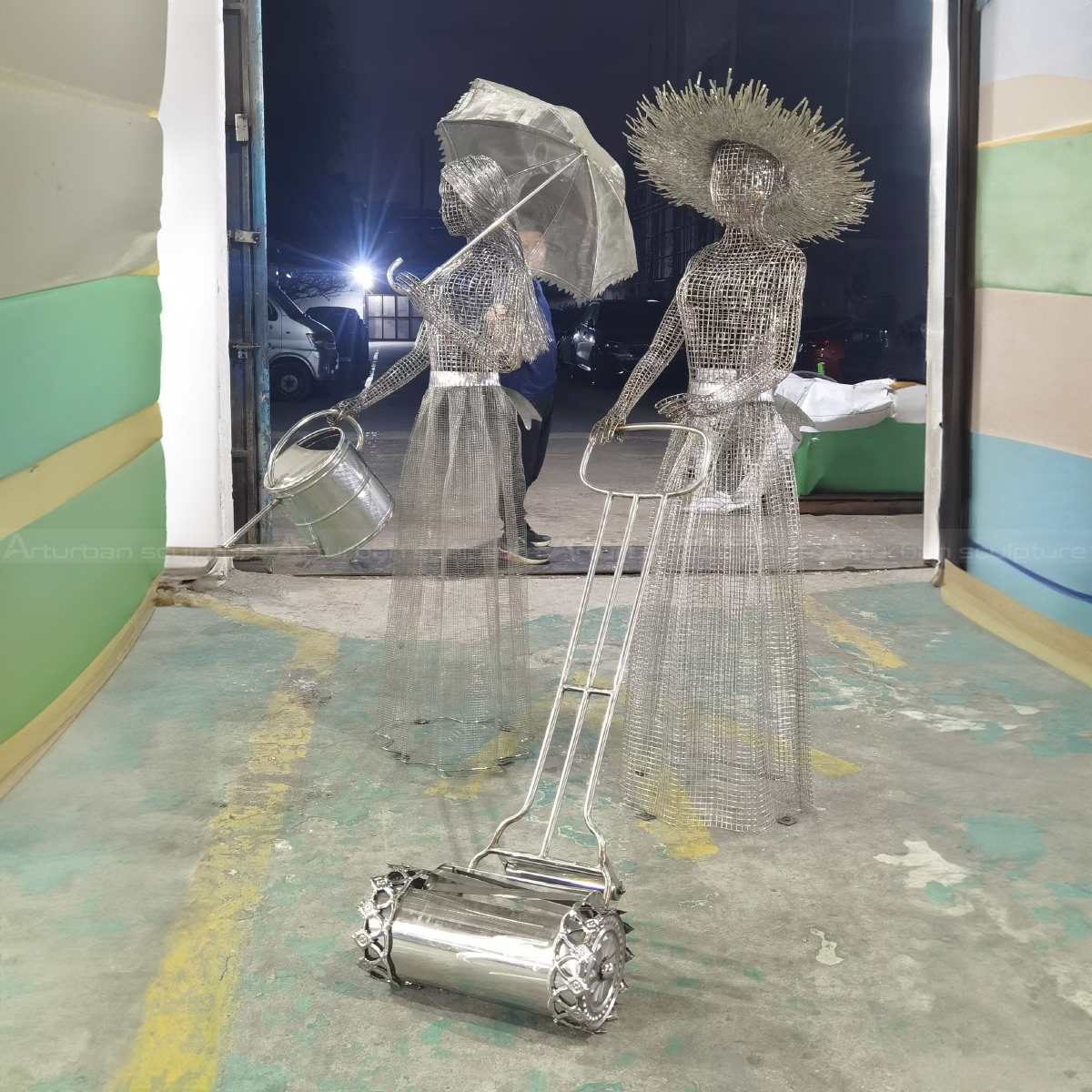 Figurative Wire Stainless steel Sculpture of one woman with an umbrella and one with a gardening roller(1)