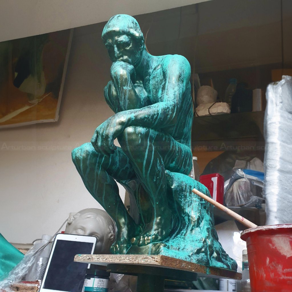 Sculpture of the Thinking Man with green patina