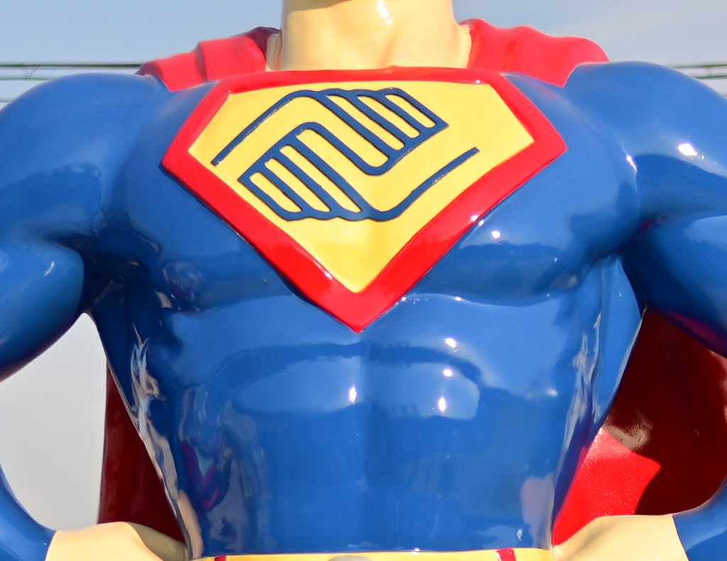 logo on the chest of superman sculpture