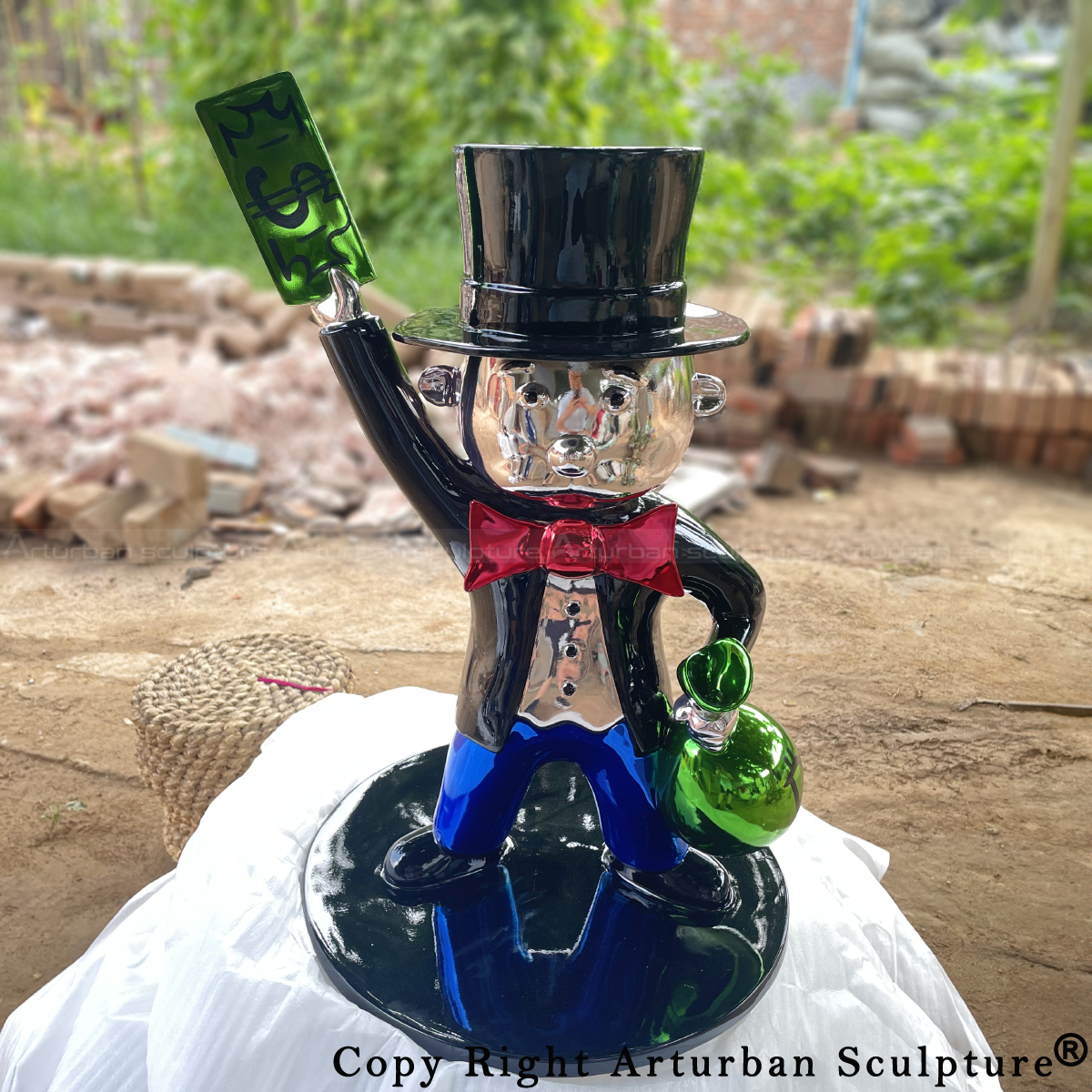 Monopoly Man sculpture with silver-faced and holding money bag and dollar bill
