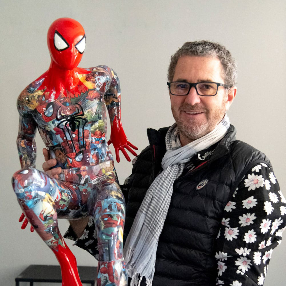 Artist Peppone holding a graffiti spiderman statue