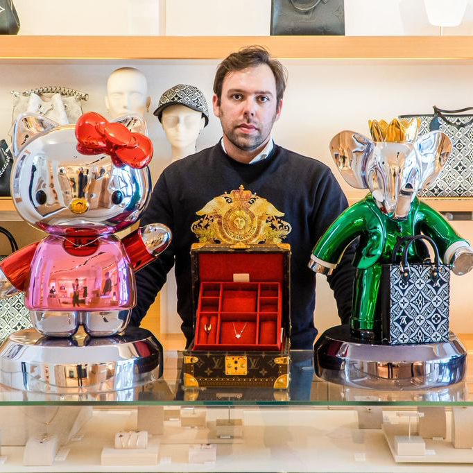 Vincent Faudemer standing between a chrome Hello Kitty and green Babolex elephant sculpture