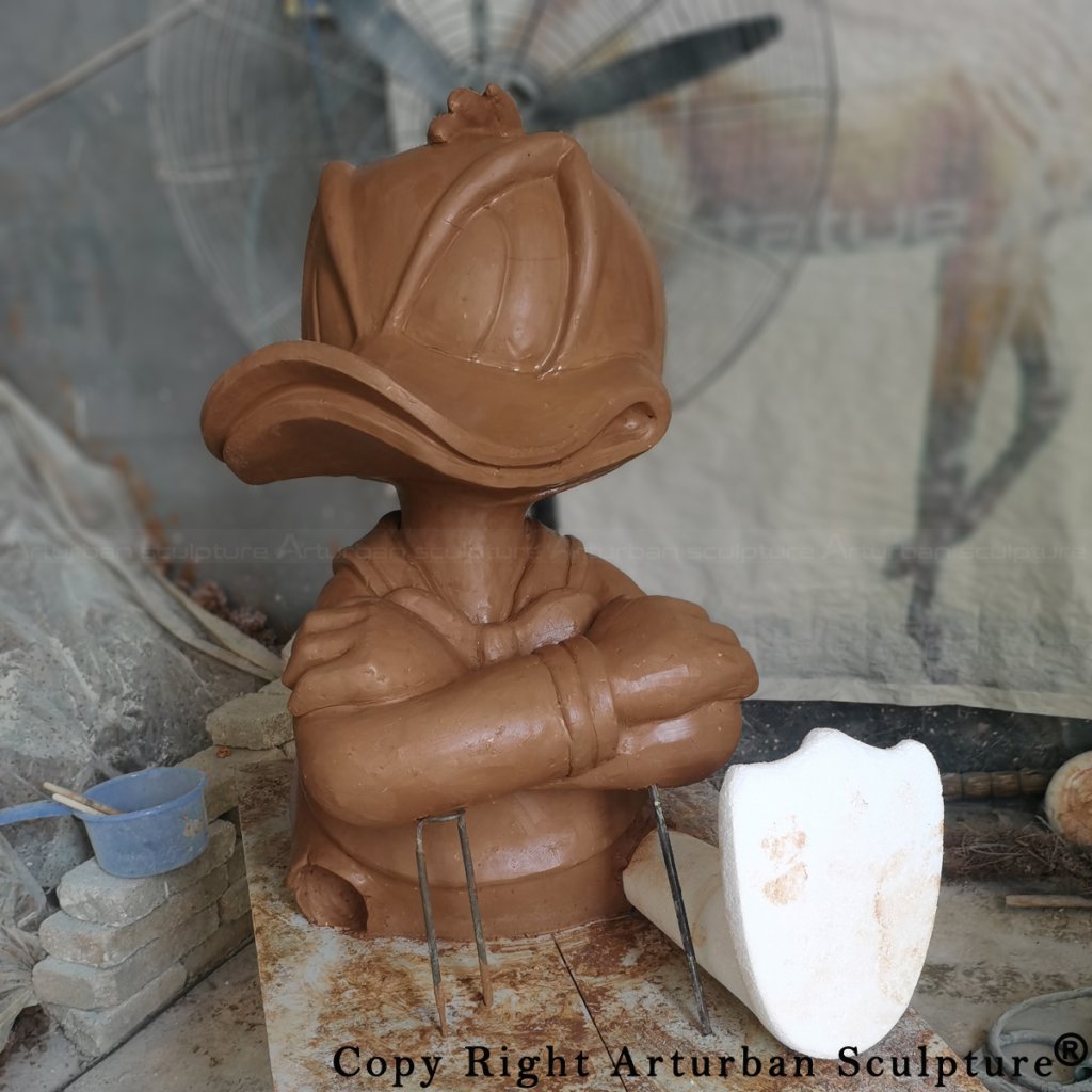 clay mold of Donald Duck suclpture with folded arms