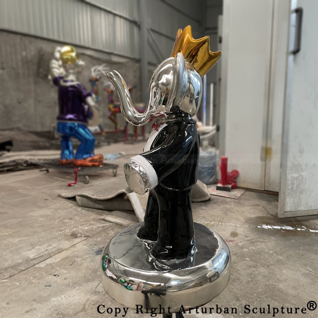 side view of Vincent Faudemer Babolex sculpture in a black suit with a golden crown