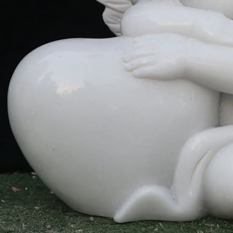 Close-up view of the sleeping cherub sculpture with delicate hands placed on the heart