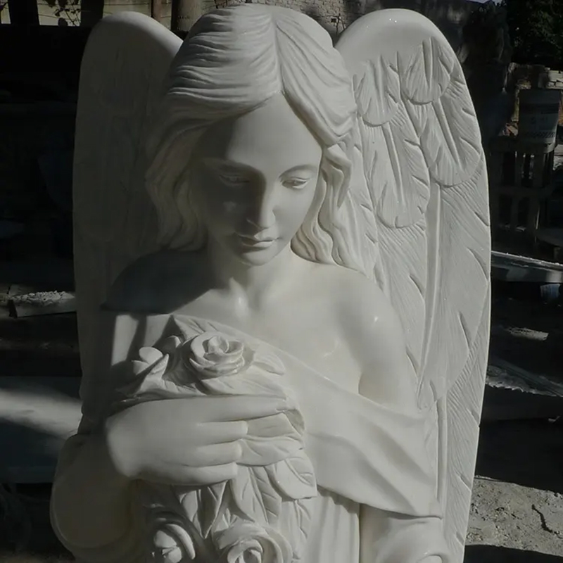 Detailed view of of white marble Cemetery Angels holding a bouquet of roses