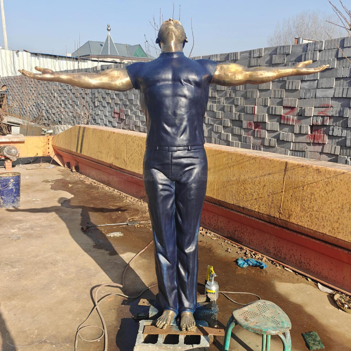 Man with Arms Out Statue looking upward