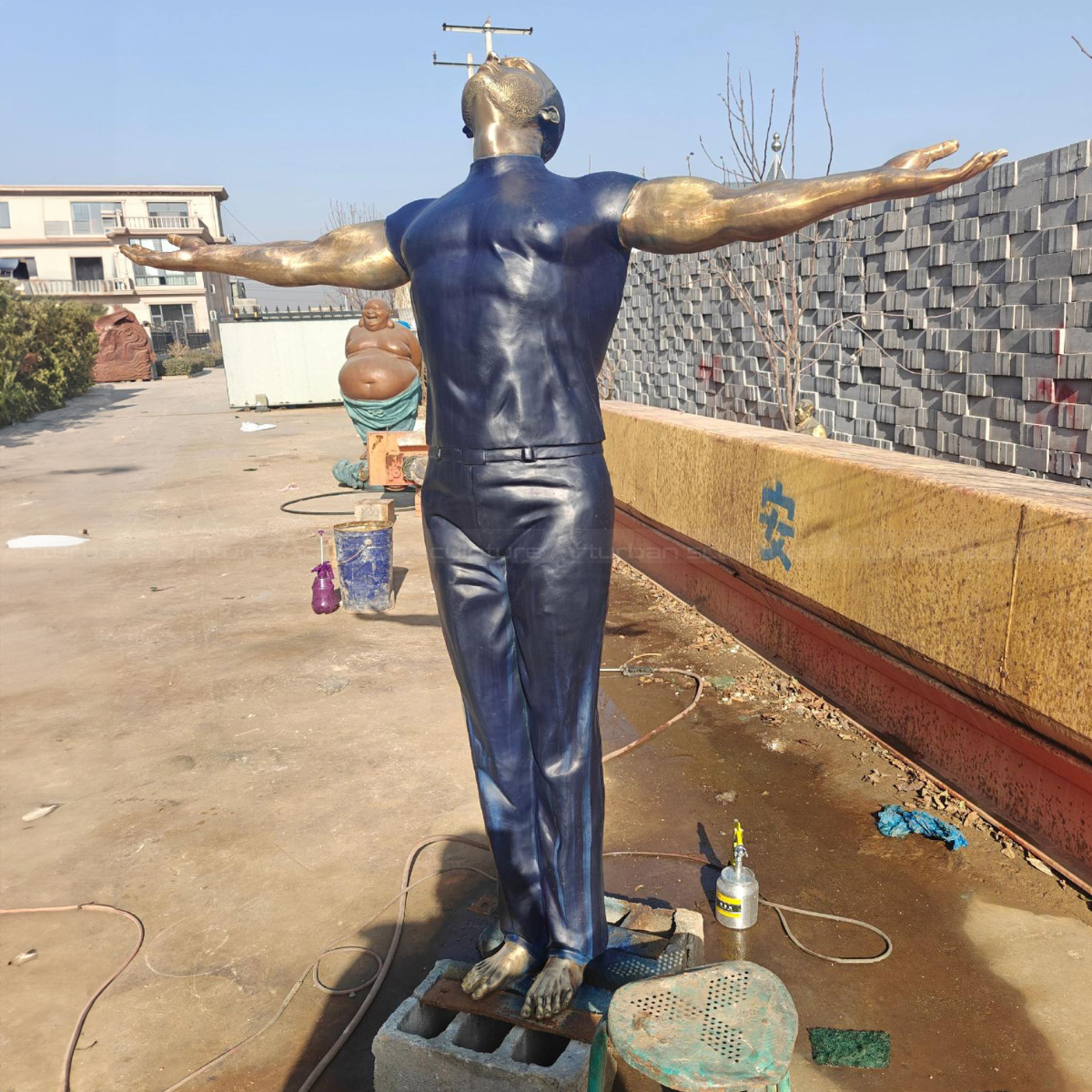 Man with Arms Out Statue showing detailed muscles
