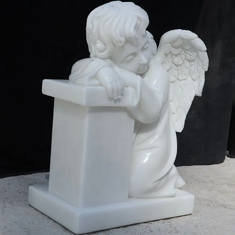 Sleeping Cherub Statuekneeling next to a tomestone