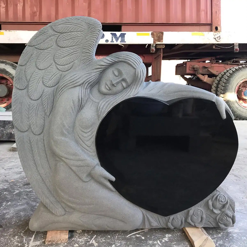angel leaning against a heart headstone Granite statue