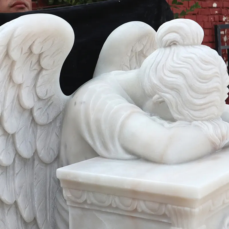 close-up view of marble angel statue showing the intricate details of the wings and the angel's posture