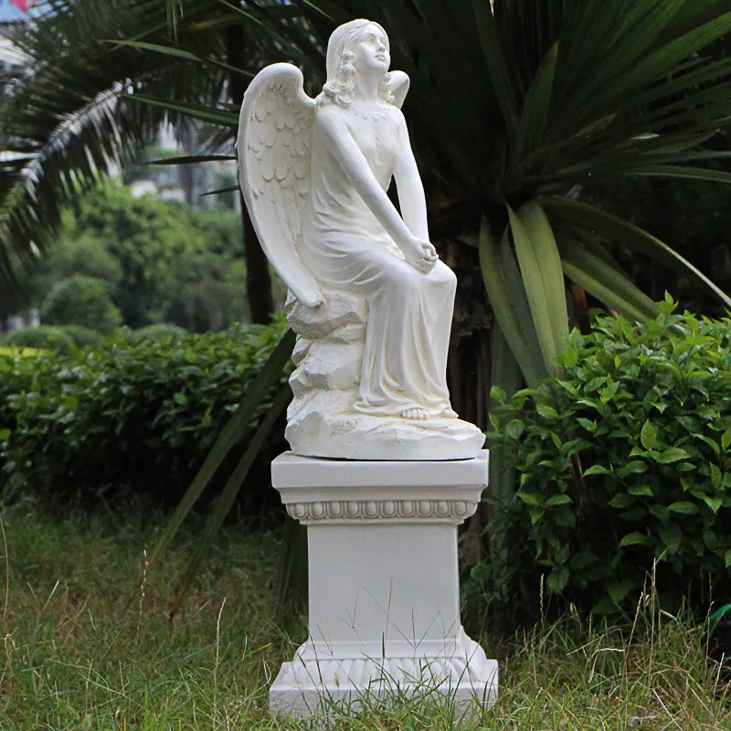 side view of an marble Angel seated on a pedestal statue for Garden