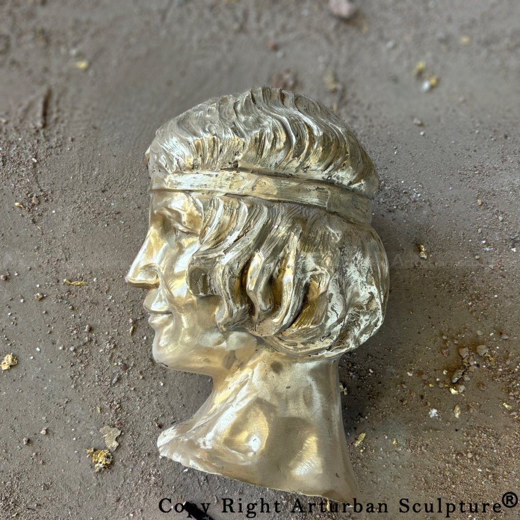 Cast bronze head segment of the kneeling angel statue, showing fine hair details