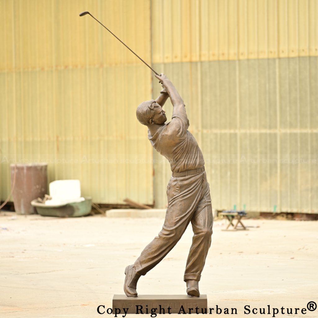 bronze Arnold Palmer statue with golf club extended overhead