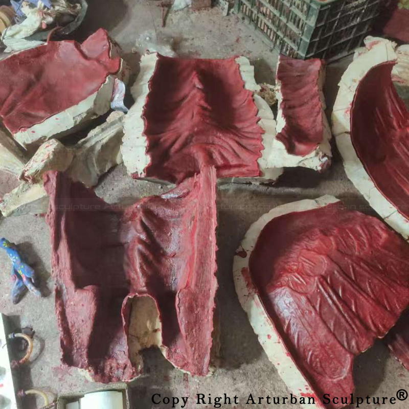 Wax molds of the kneeling angel statue laid out in segments