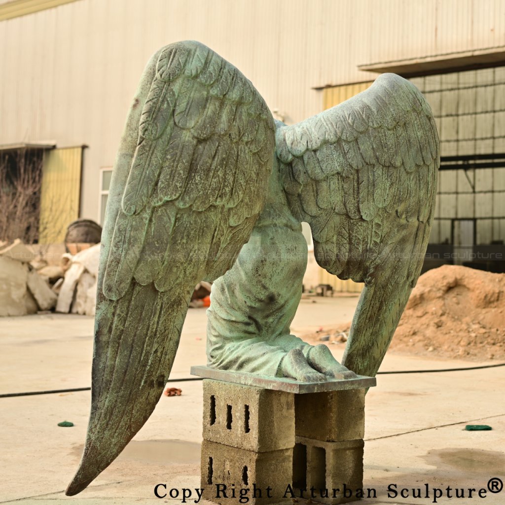 Rear side view of the patina-finished bronze kneeling angel statue