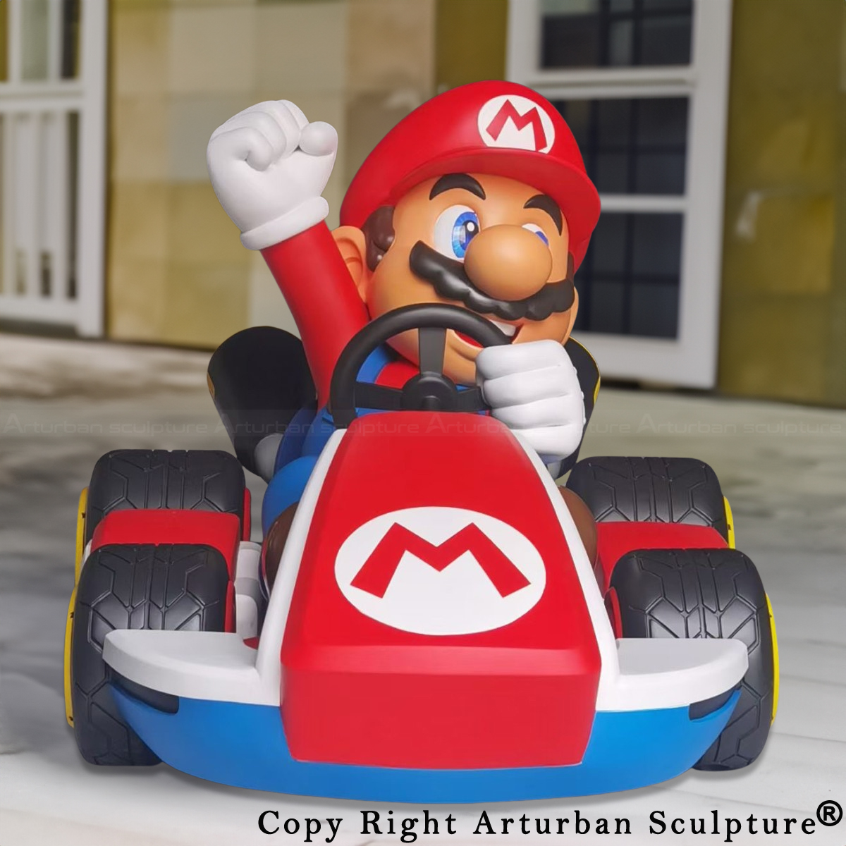 Big Mario fiberglass Statue with Mario raising his fist while driving a red and blue go-kart