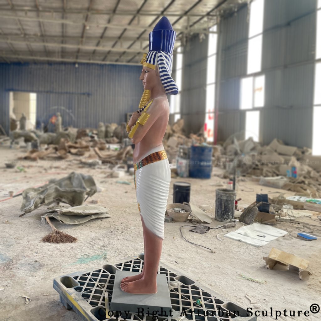 Side view of a fiberglass pharaoh sculpture with blue crown and striped Nemes headcloth