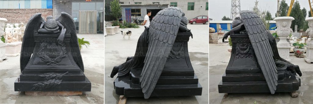 black marble grief angel statue with wings draped forward, leaning over a tombstone