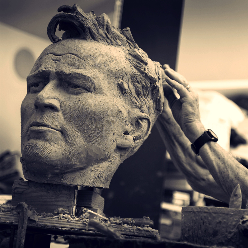 sculptor Bruce Wolfe shaping a clay portrait of Arnold Palmer by hand