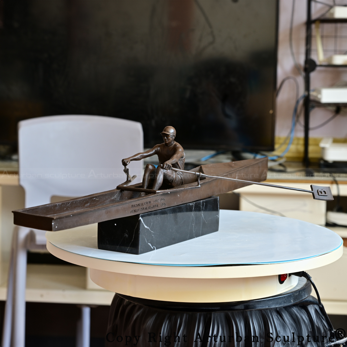 bronze rowing sculpture featuring seated rower