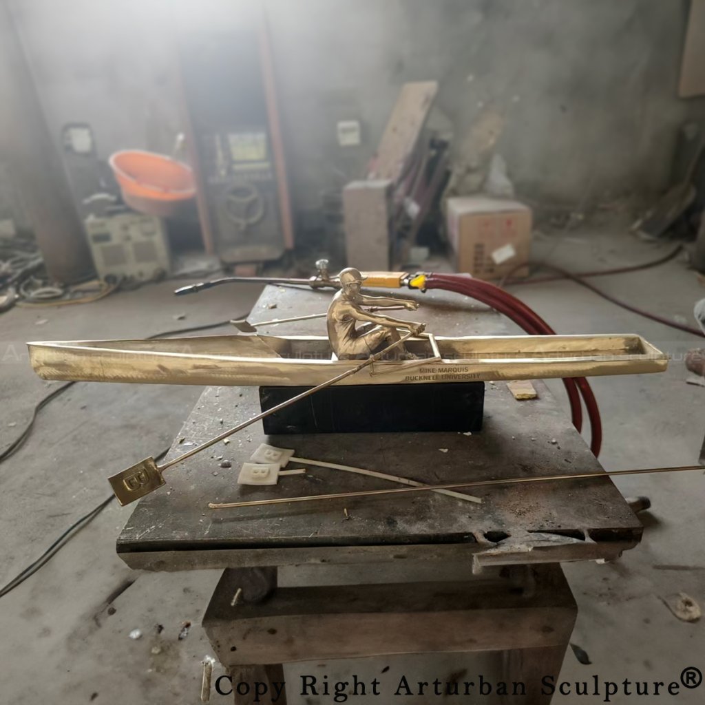 Polishing stage of a bronze rowing sculpture before patina
