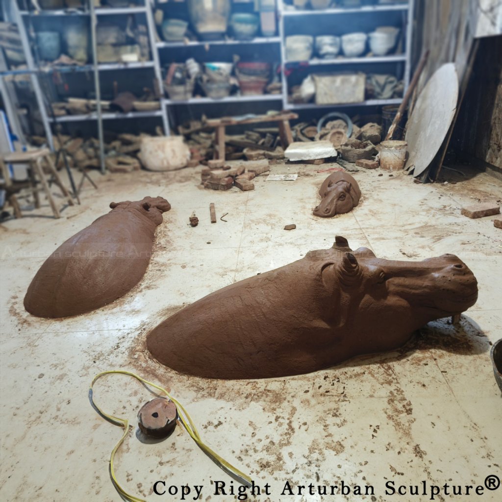 Studio workspace showing a full set of clay-modeled Bronze Hippopotamus sculptures