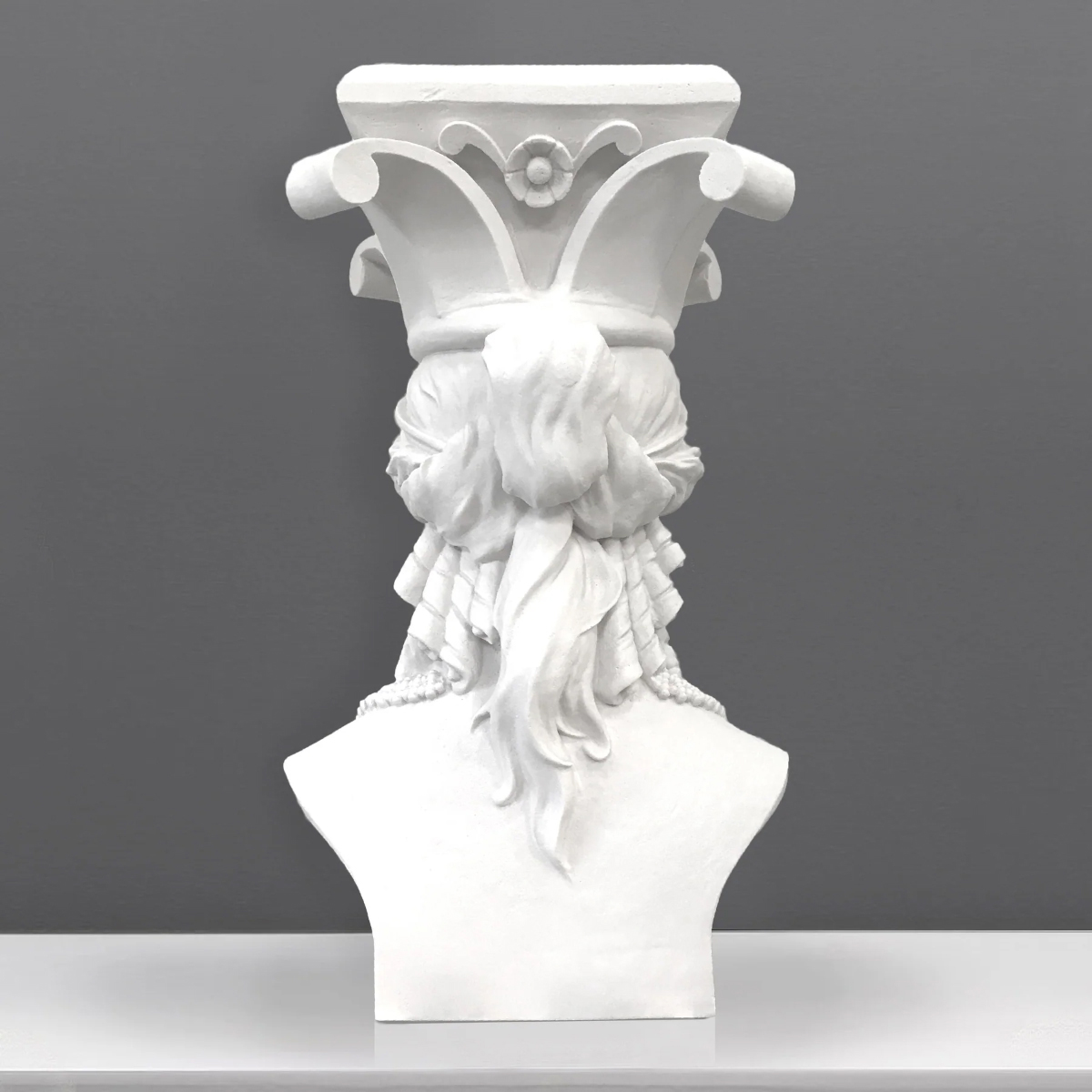 A back view of the Caryatid bust Sculpture, showing the detailed flowing hair