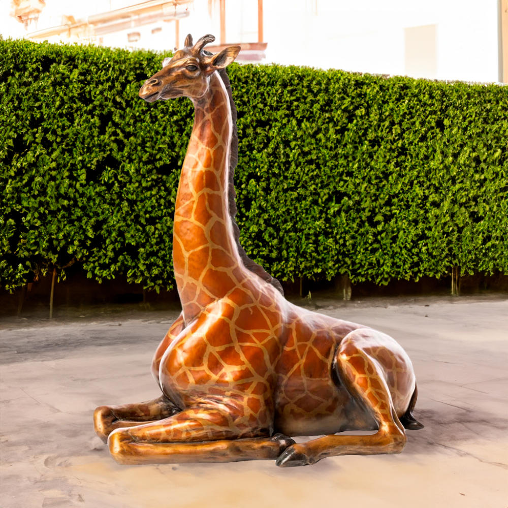 A lifelike Giraffe Bronze Sculpture featuring a resting reticulated giraffe