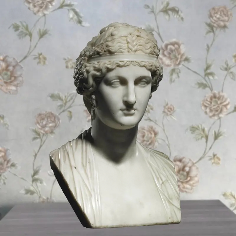 A neoclassical Female Head Bust in marble, depicting a serene woman with wavy hair and a classical headband