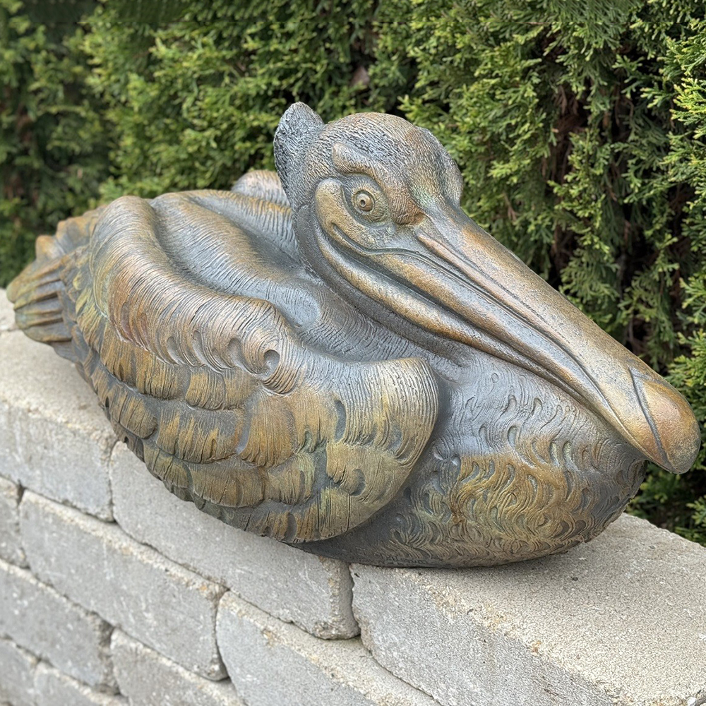 Bronze Pelican Sculpture resting on garden wall