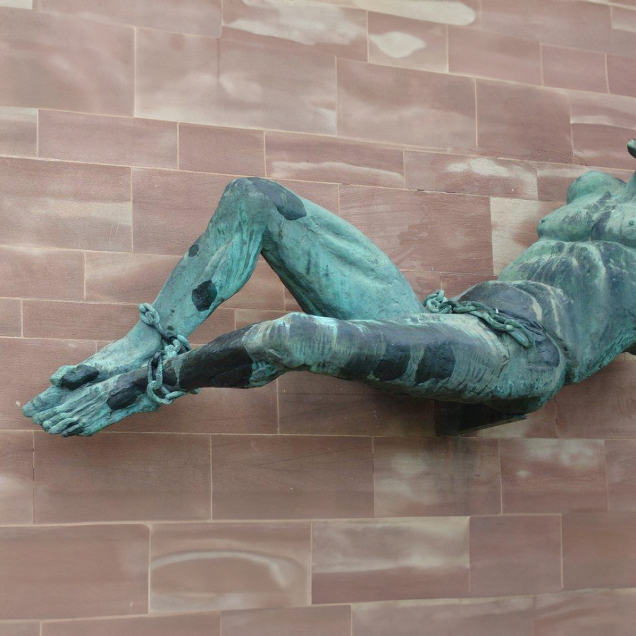 Close-up of chained Satan figure from the Coventry Cathedral wall sculpture
