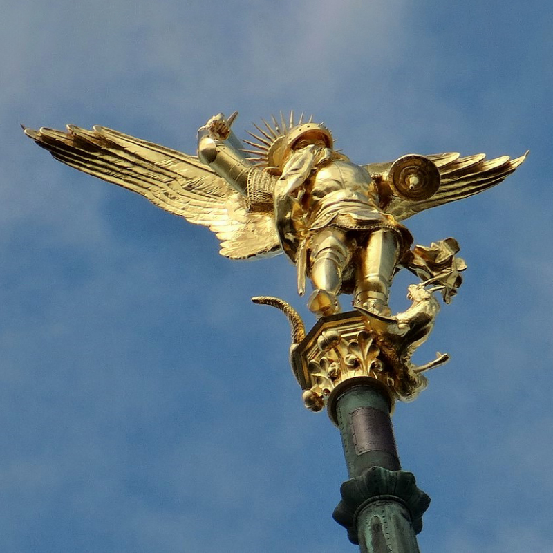 Close-up of golden Archangel Michael slaying the dragon