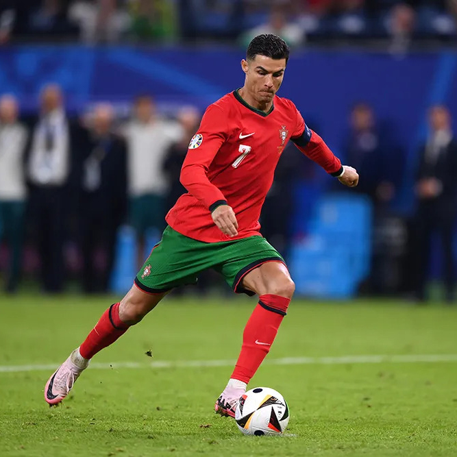 Cristiano Ronaldo wearing Portugal's national team kit, mid-action while controlling the ball