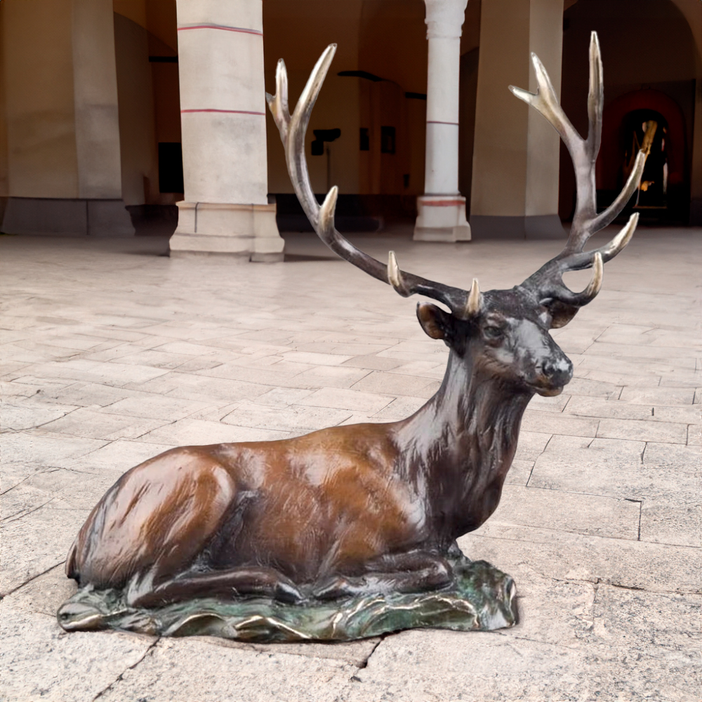 Life Size Metal Deer Statue of reclining elk with bronze finish and polished antlers on natural-style base