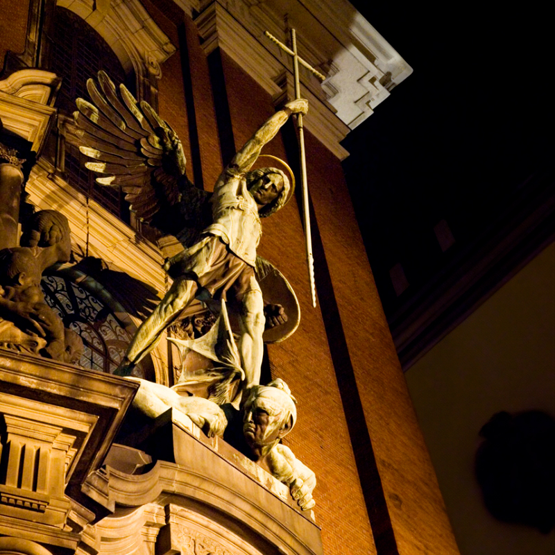 Night view of St. Michael statue slaying the devil