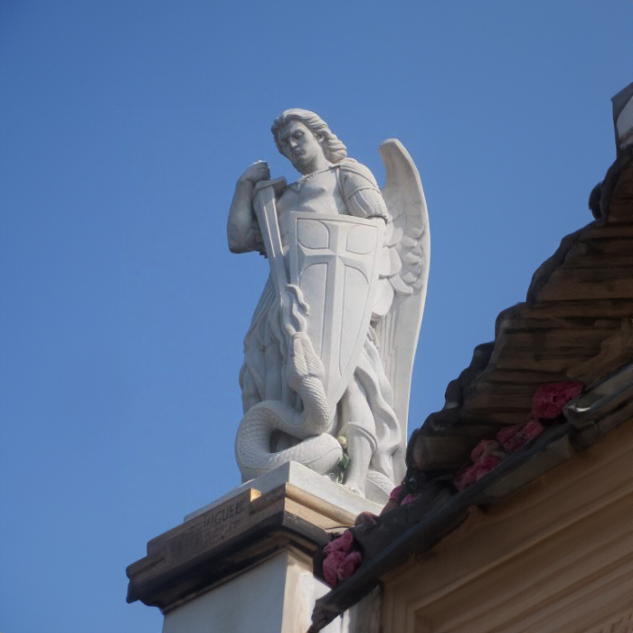Rooftop statue of Saint Michael defeating a serpent with shield and sword