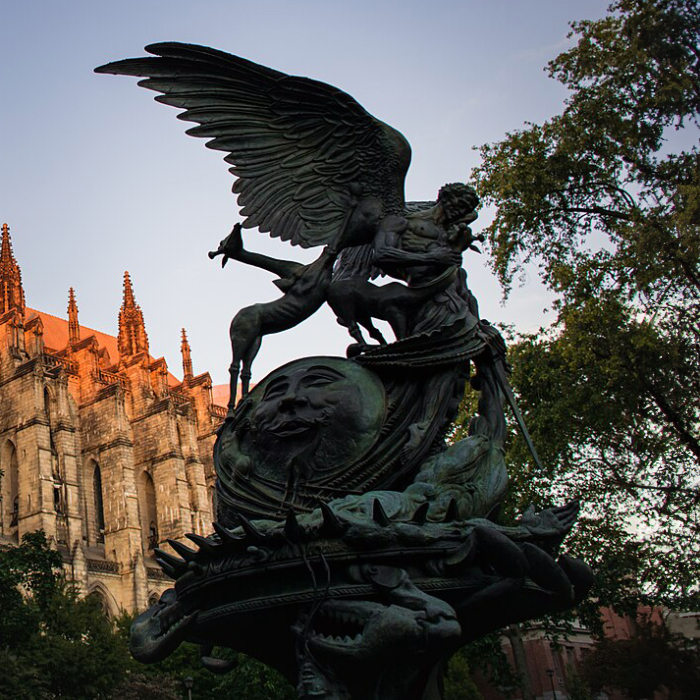 Silhouetted Peace Fountain sculpture with Archangel Michael at sunset in New York City