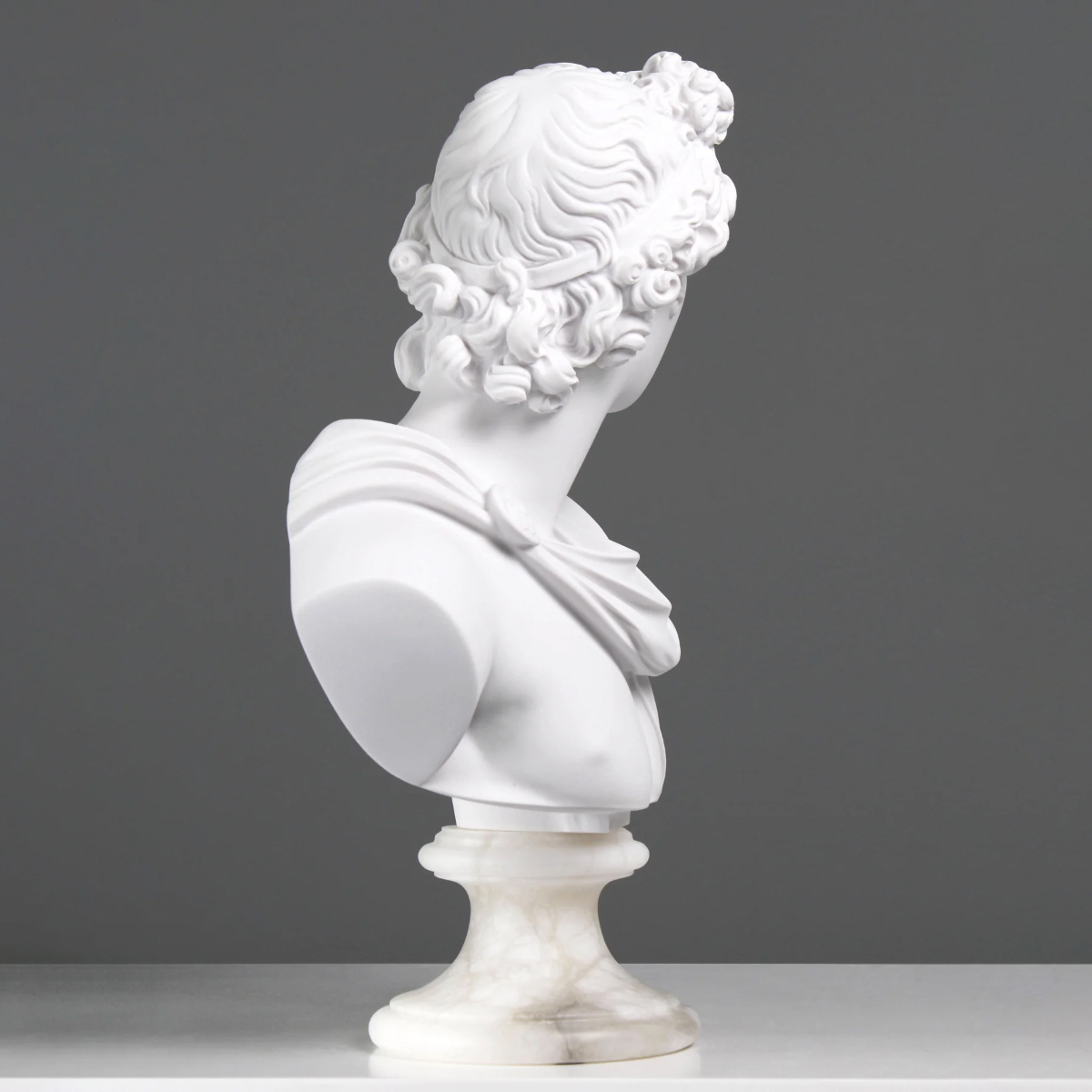 side angle of the Apollo Head Sculpture in marble, featuring detailed hair texture