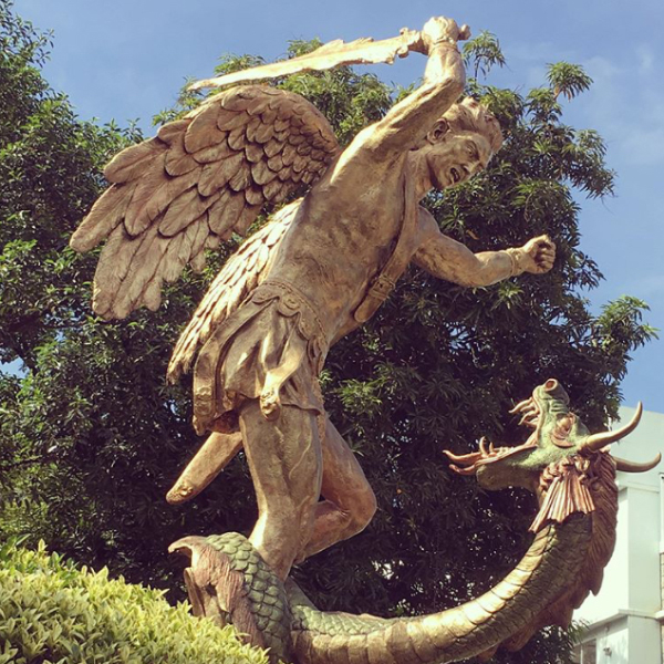 statue of Archangel Michael striking a dragon with his sword