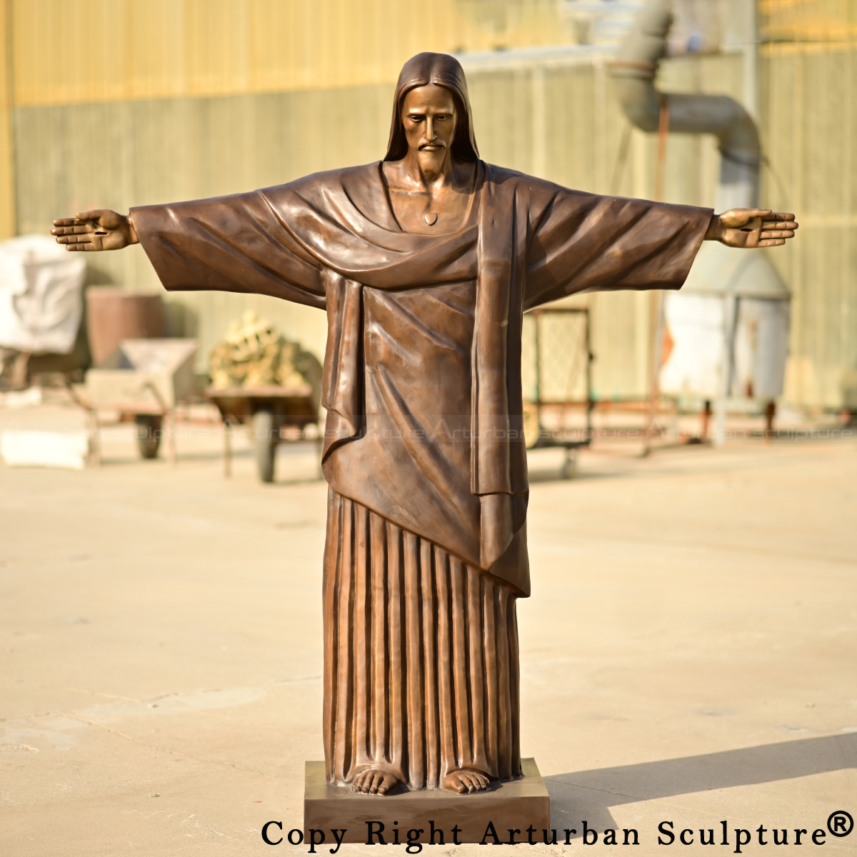 Frontal image of the bronze Jesus Christ the Redeemer Statue, featuring stigmata details and solemn expression