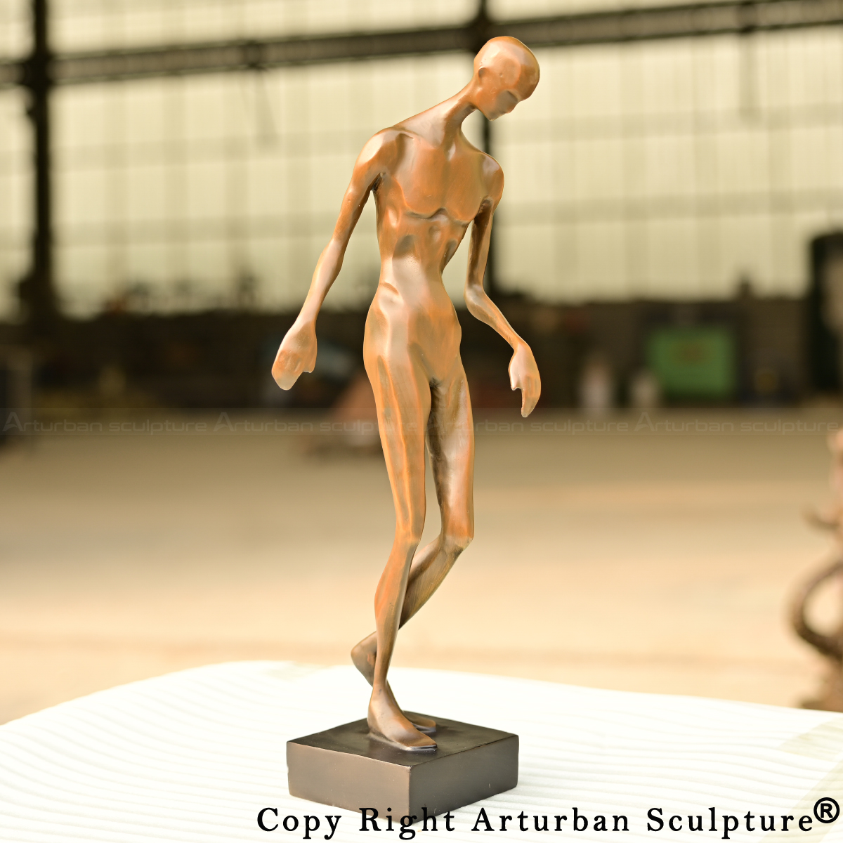 0-Modern abstract human sculpture rendered in smooth bronze with a bowed head and arched back