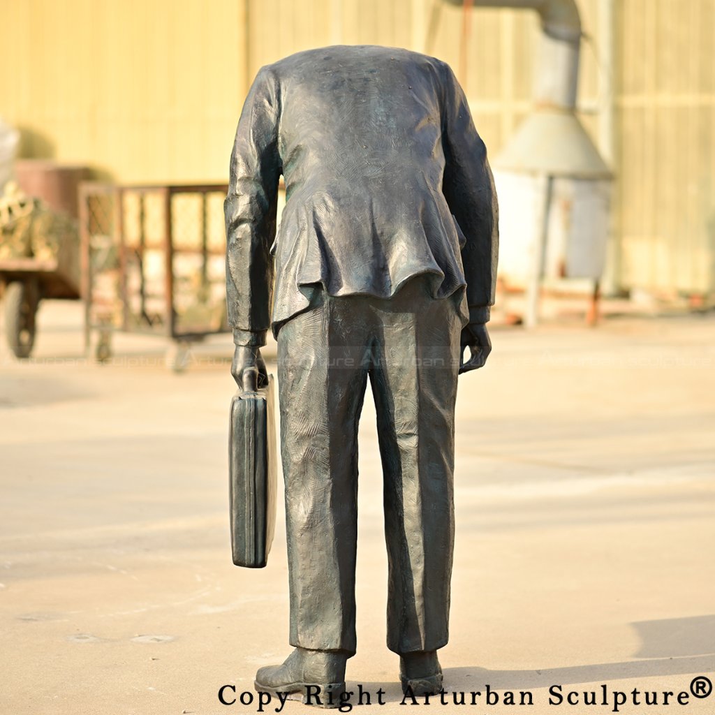 bronze Corporate Head Sculpture, depicting a bent-over figure with no head
