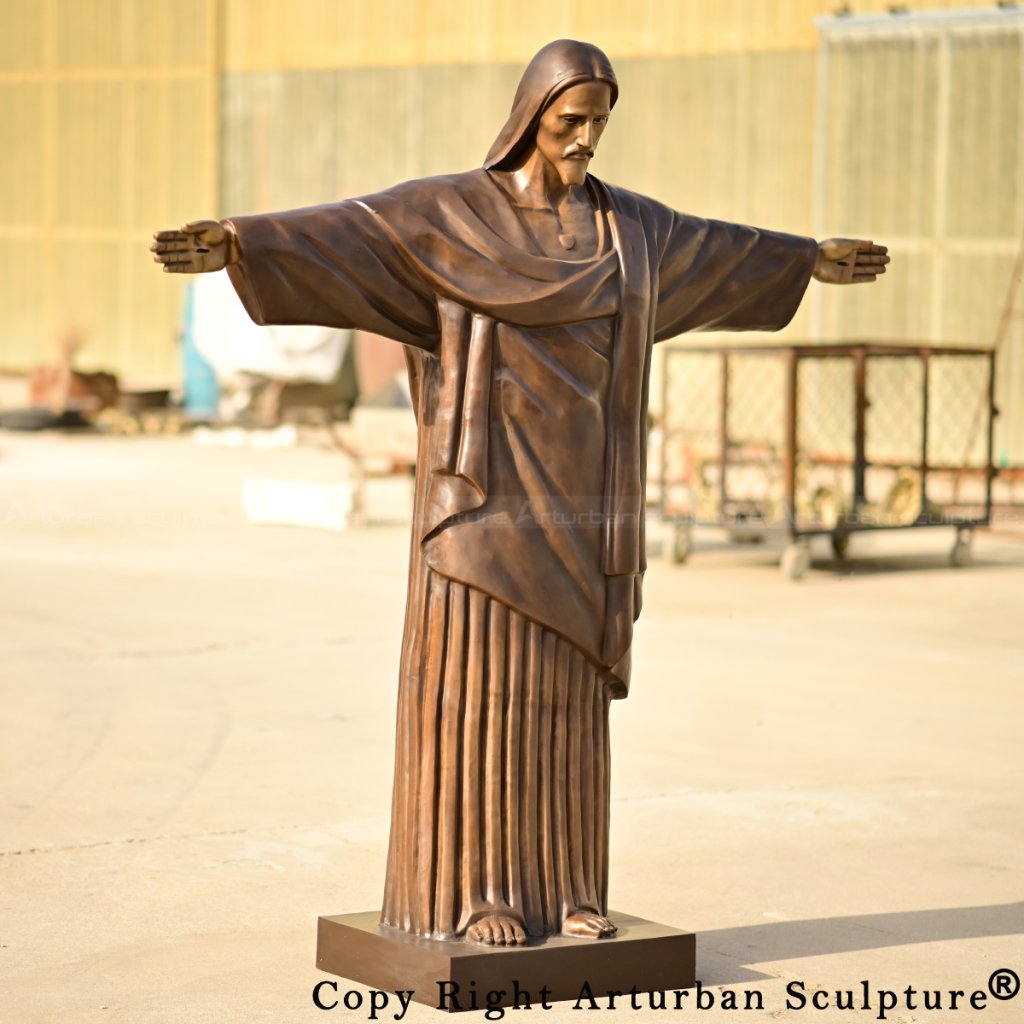 Front view of a bronze Jesus Christ the Redeemer Statue with outstretched arms and detailed robe folds